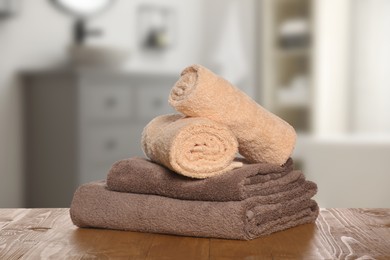 Image of Stack of fresh towels on table against blurred bathroom interior