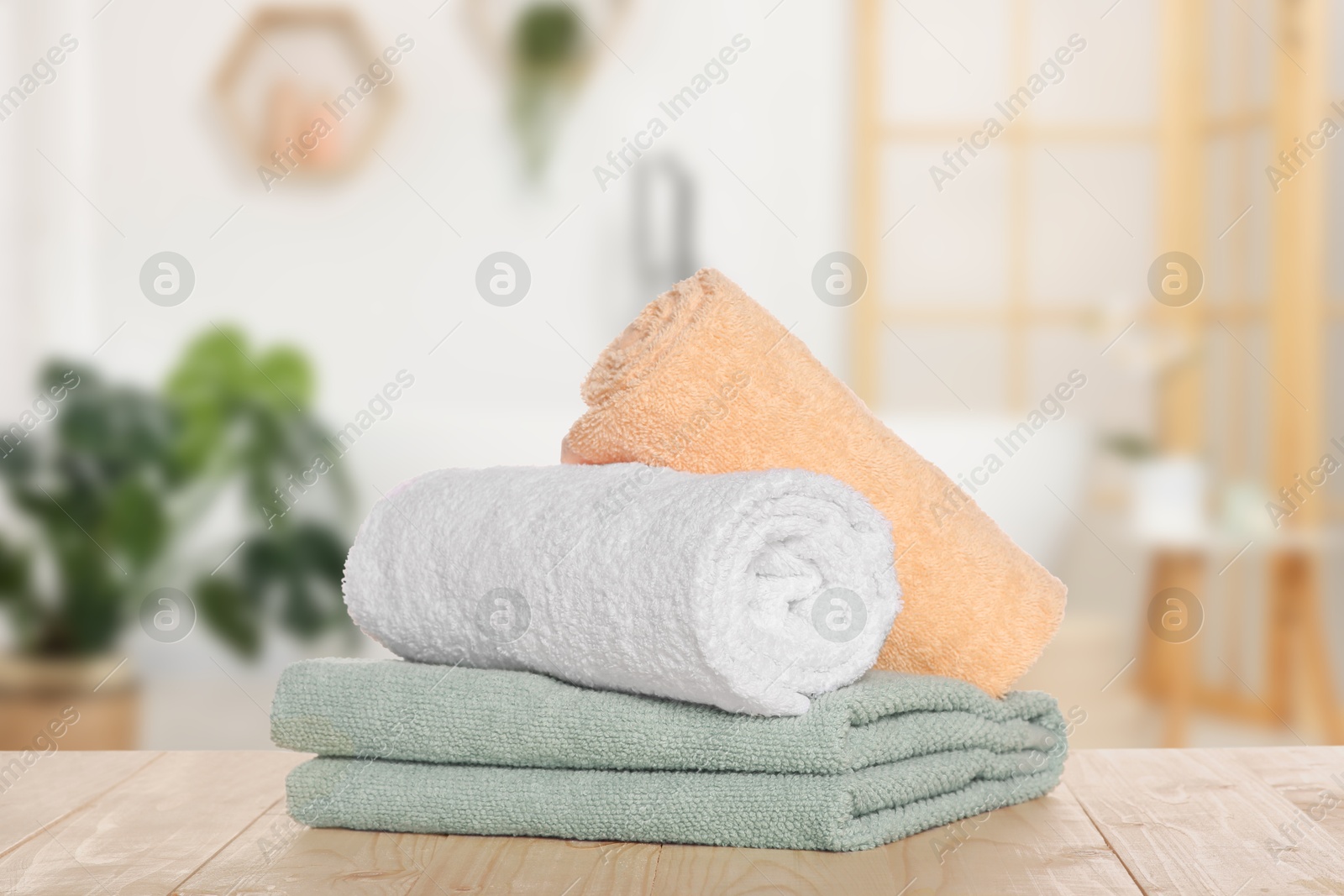 Image of Stack of fresh towels on table against blurred bathroom interior