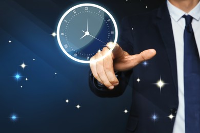 Businessman touching virtual clock on dark background, closeup