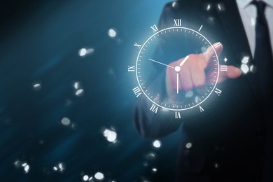 Image of Businessman touching virtual clock on dark background, closeup
