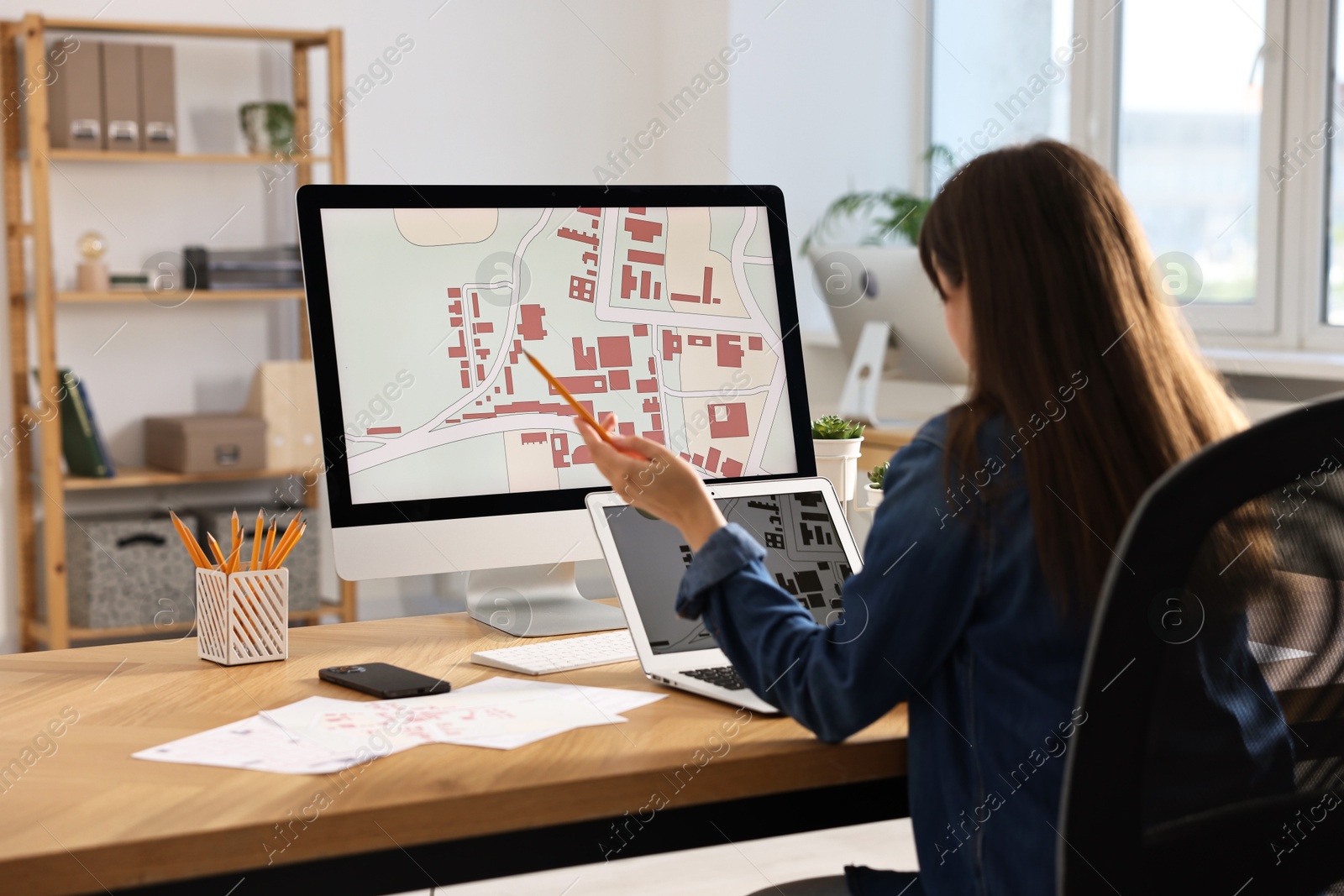 Photo of Cartographer working with cadastral maps at table in office