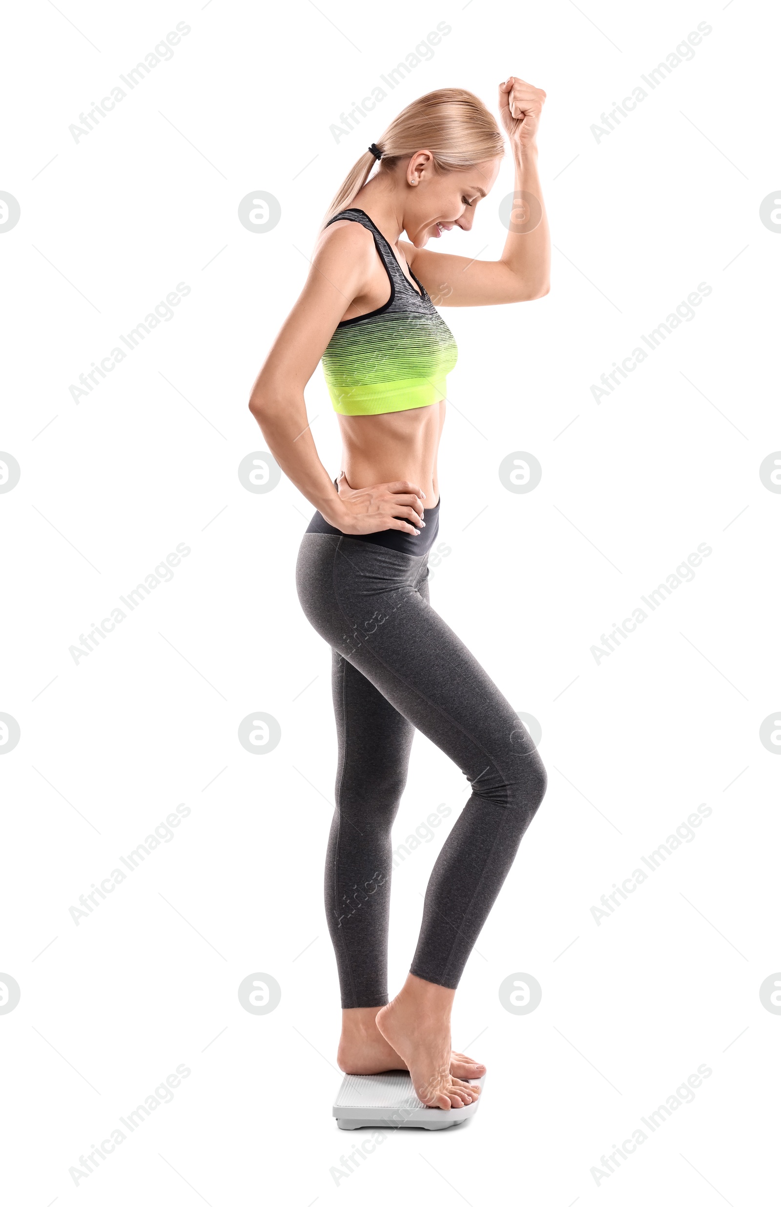 Photo of Happy woman standing on floor scale against white background