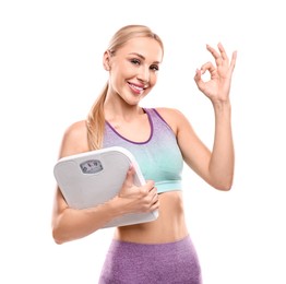 Happy woman with floor scale showing ok gesture on white background