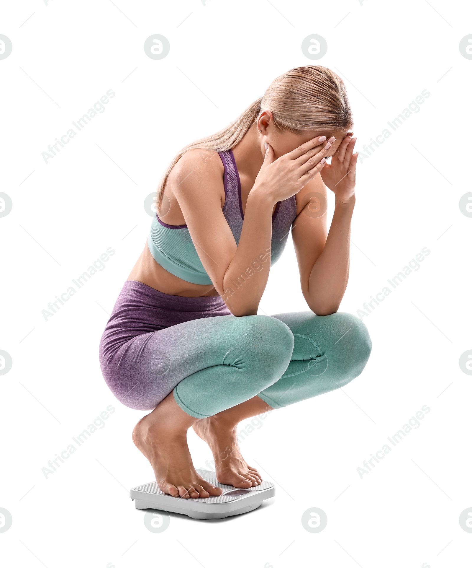 Photo of Upset woman covering face with hands on floor scale against white background