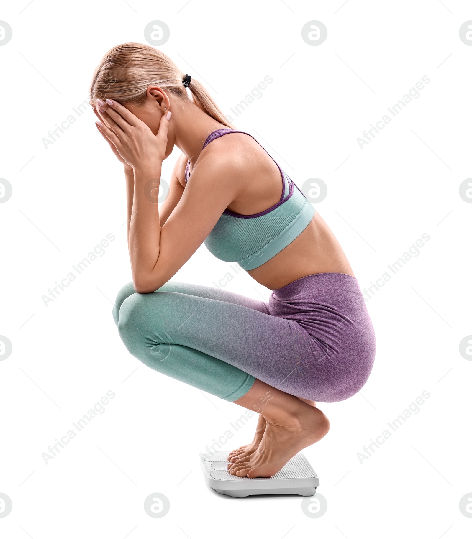 Photo of Upset woman covering face with hands on floor scale against white background