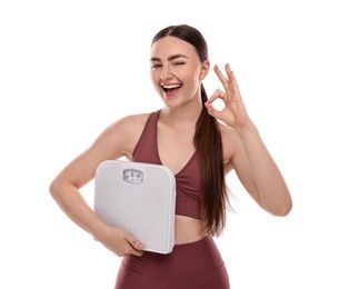 Happy woman with floor scale showing ok gesture on white background