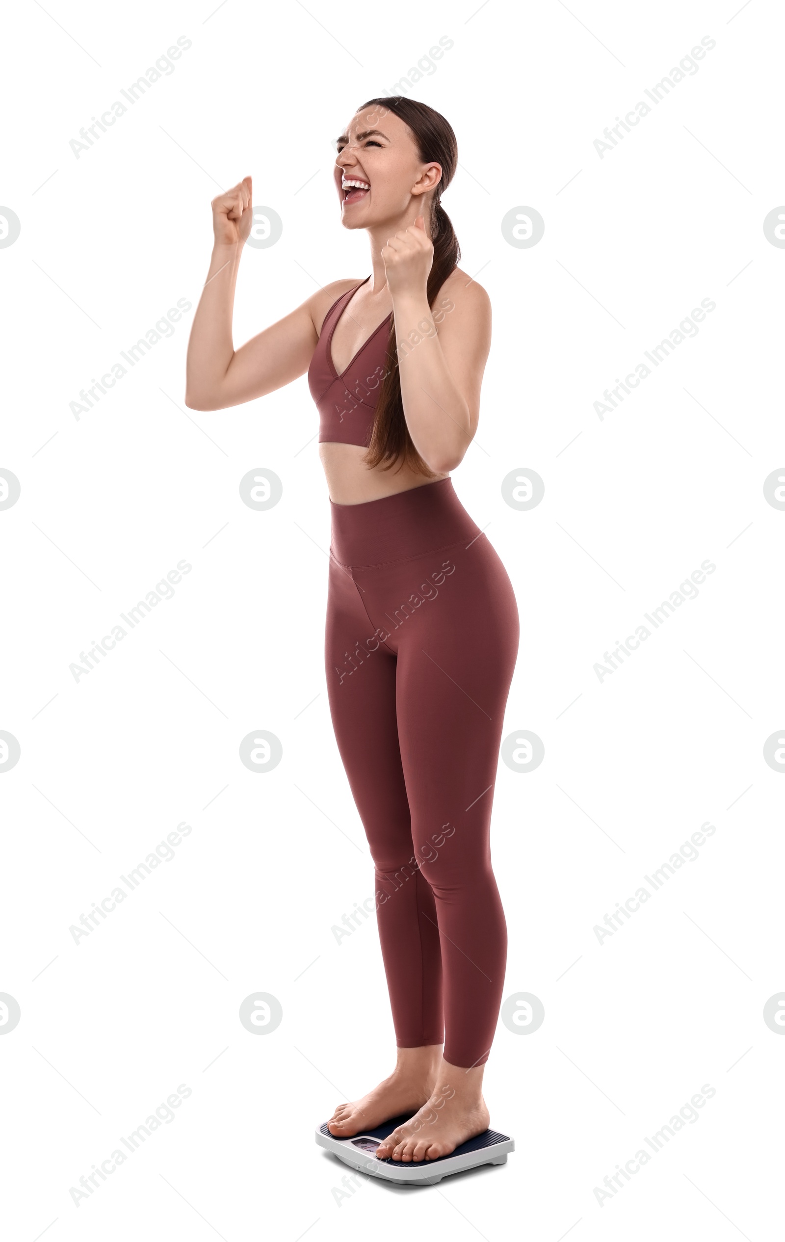 Photo of Happy woman standing on floor scale against white background