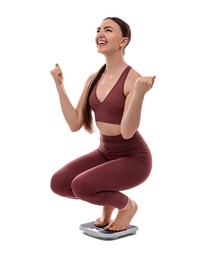 Happy woman on floor scale against white background