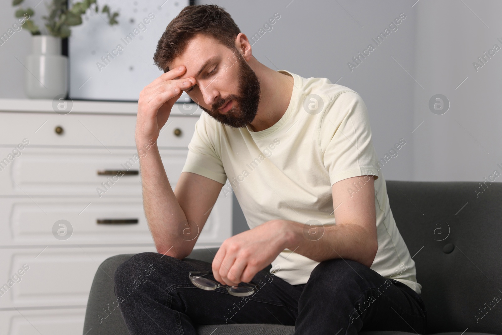 Photo of Overwhelmed man with glasses suffering at home