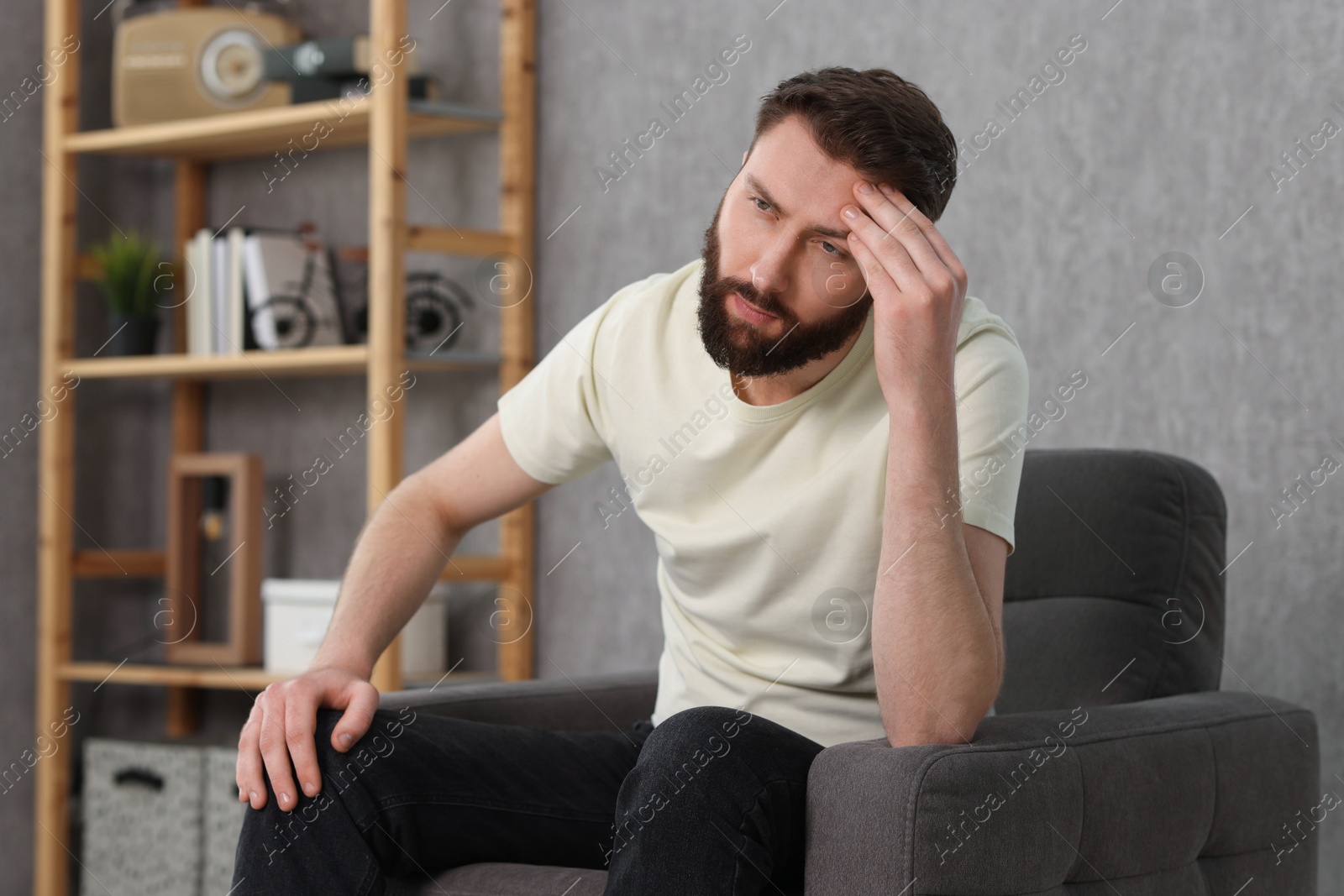 Photo of Overwhelmed man sitting in armchair at home