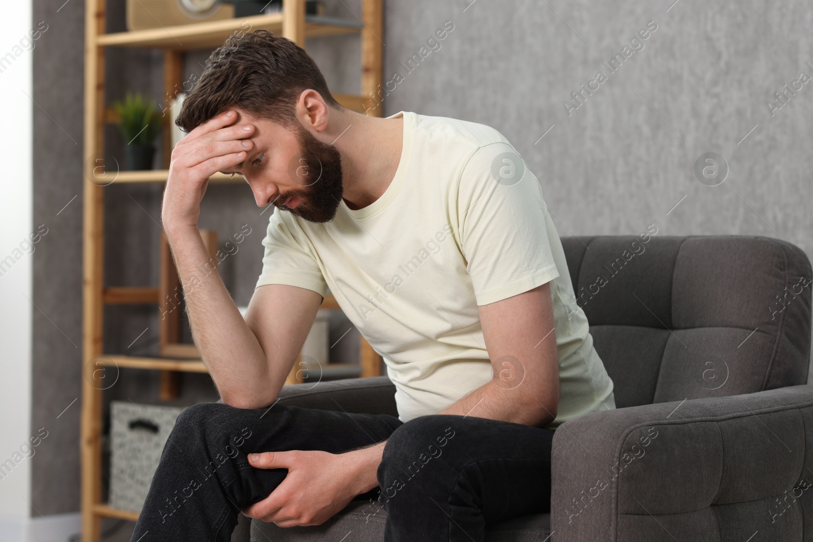 Photo of Overwhelmed man sitting in armchair at home