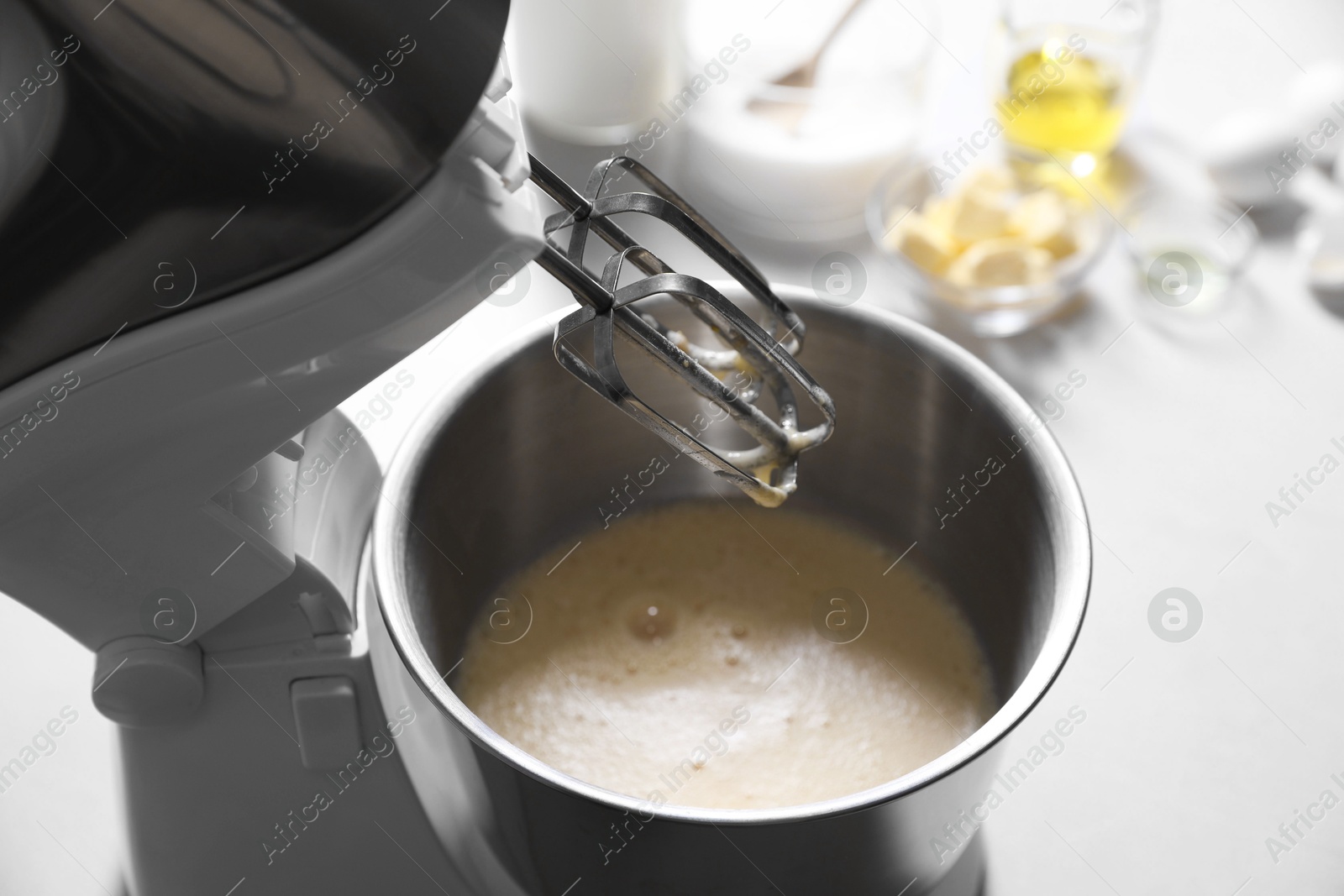 Photo of Making dough in bowl of stand mixer on white table