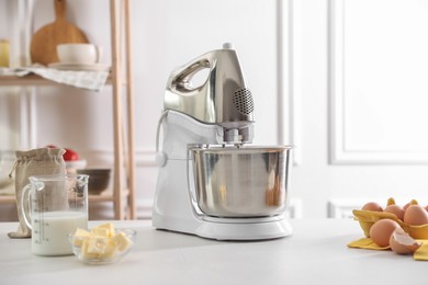 Modern stand mixer and ingredients for dough on white table indoors