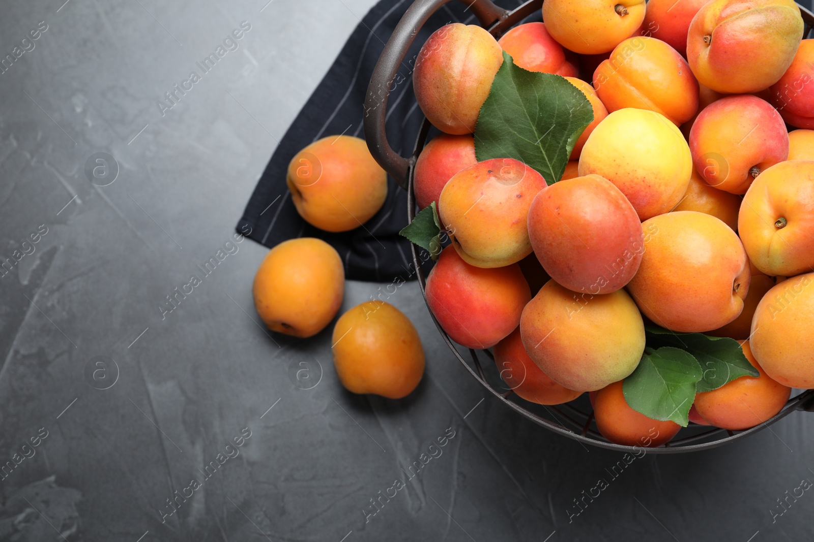 Photo of Delicious fresh ripe apricots on dark table, flat lay. Space for text