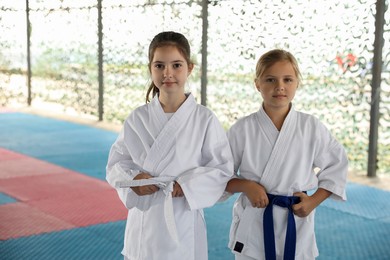 Photo of Children in kimono during karate practice on tatami outdoors