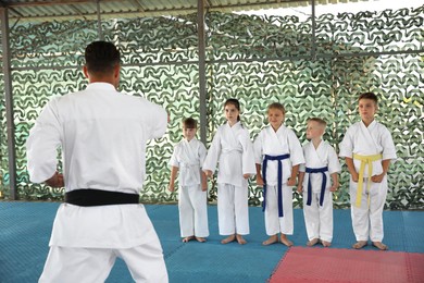 Photo of Children and coach during karate practice at outdoor gym