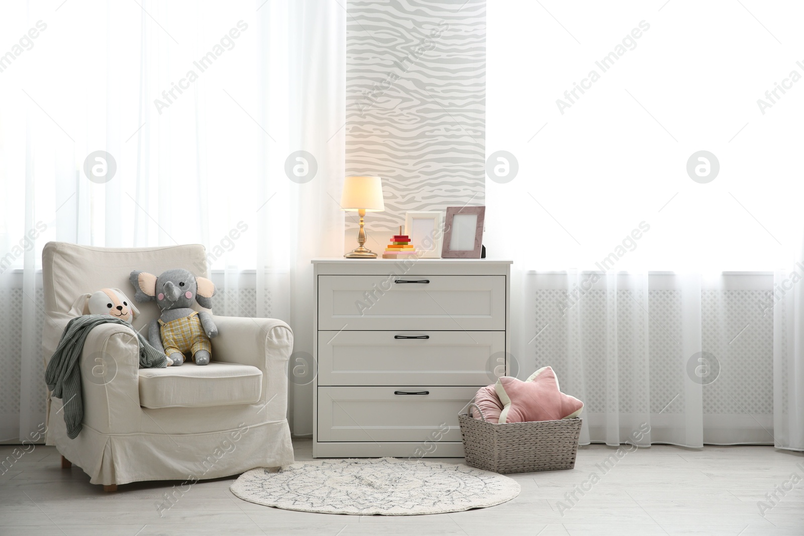 Photo of Comfortable armchair in modern baby room interior