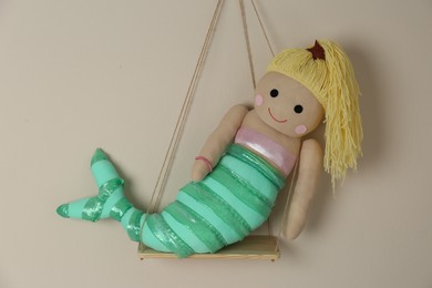 Photo of Shelf with cute toy mermaid on beige wall. Child's room interior element