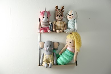 Photo of Shelf with cute toys on light wall. Baby room interior element