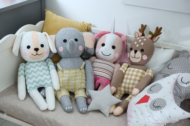 Cute toys and pillows on bed in baby room. Interior elements