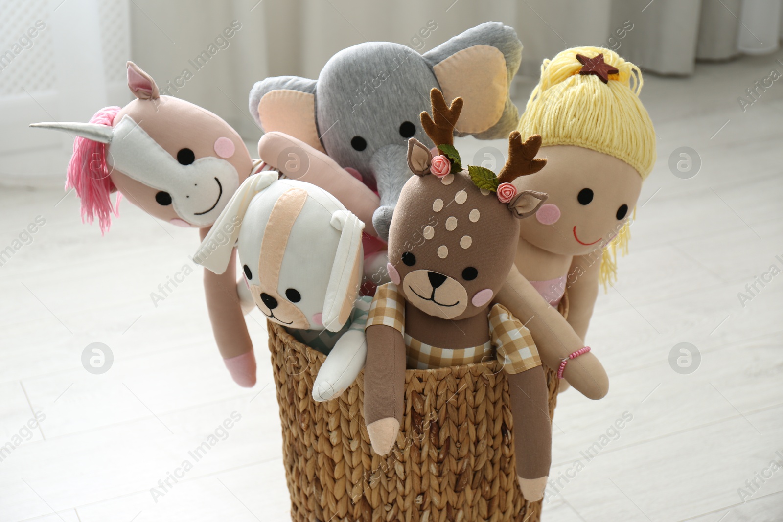 Photo of Funny toys in basket on floor. Decor for children's room interior