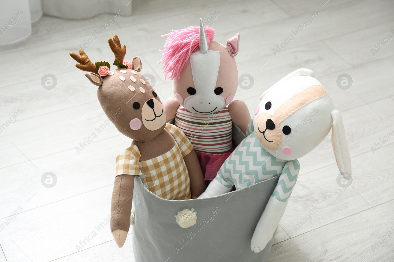 Photo of Funny toys in basket on floor. Decor for children's room interior