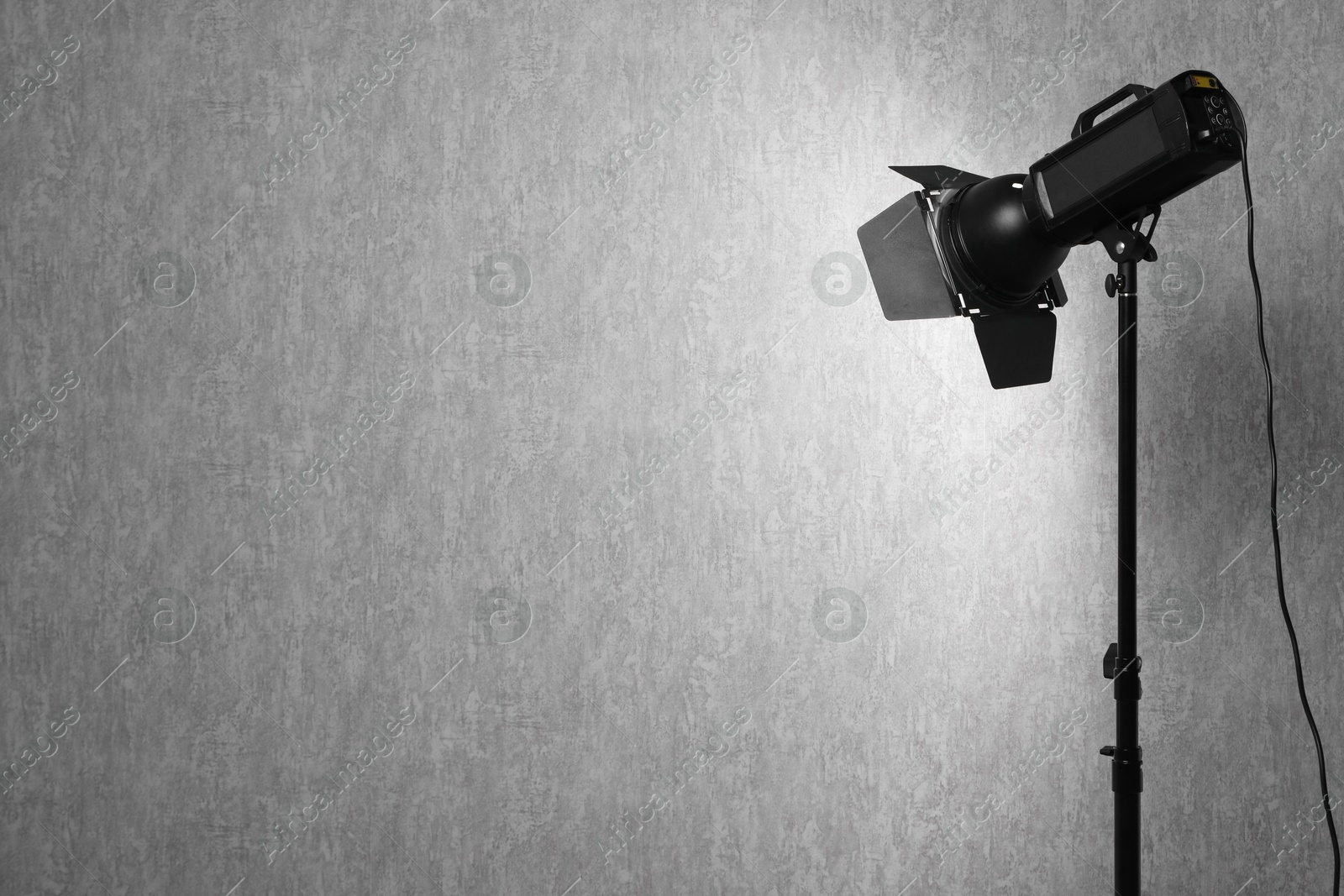 Photo of Grey photo background and professional lighting equipment in studio, space for text