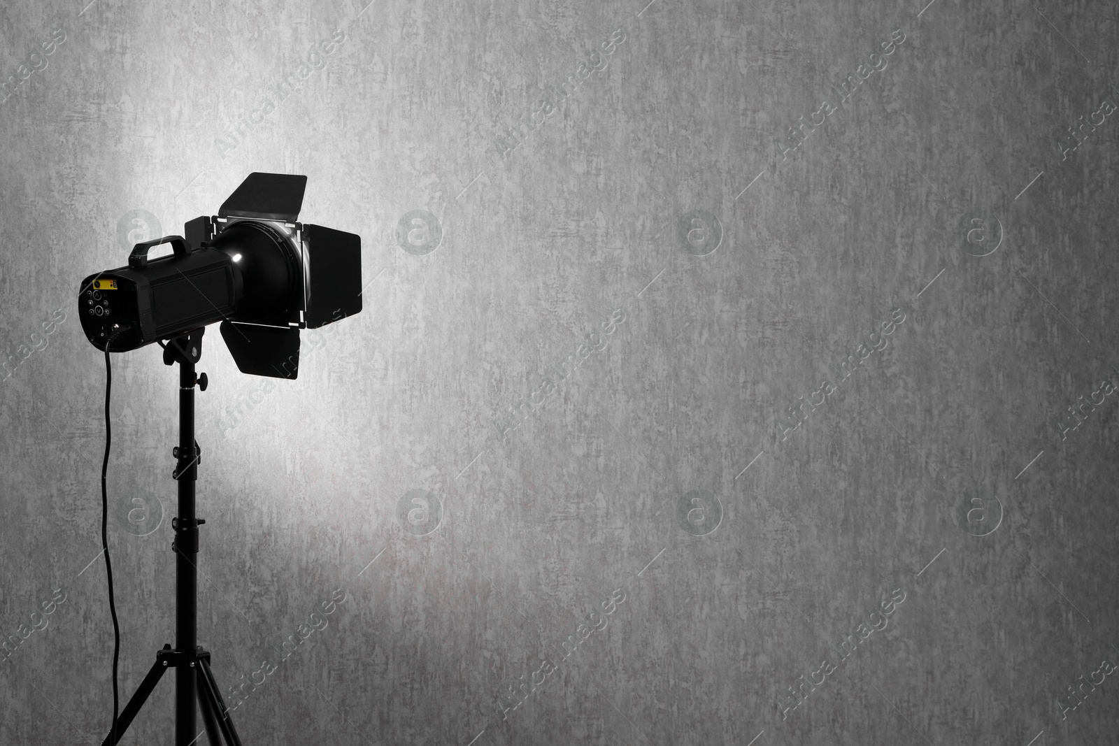 Photo of Grey photo background and professional lighting equipment in studio, space for text