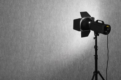 Grey photo background and professional lighting equipment in studio, space for text