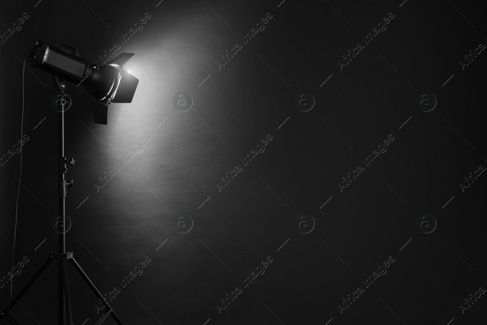 Photo of Dark photo background and professional lighting equipment in studio. Space for text