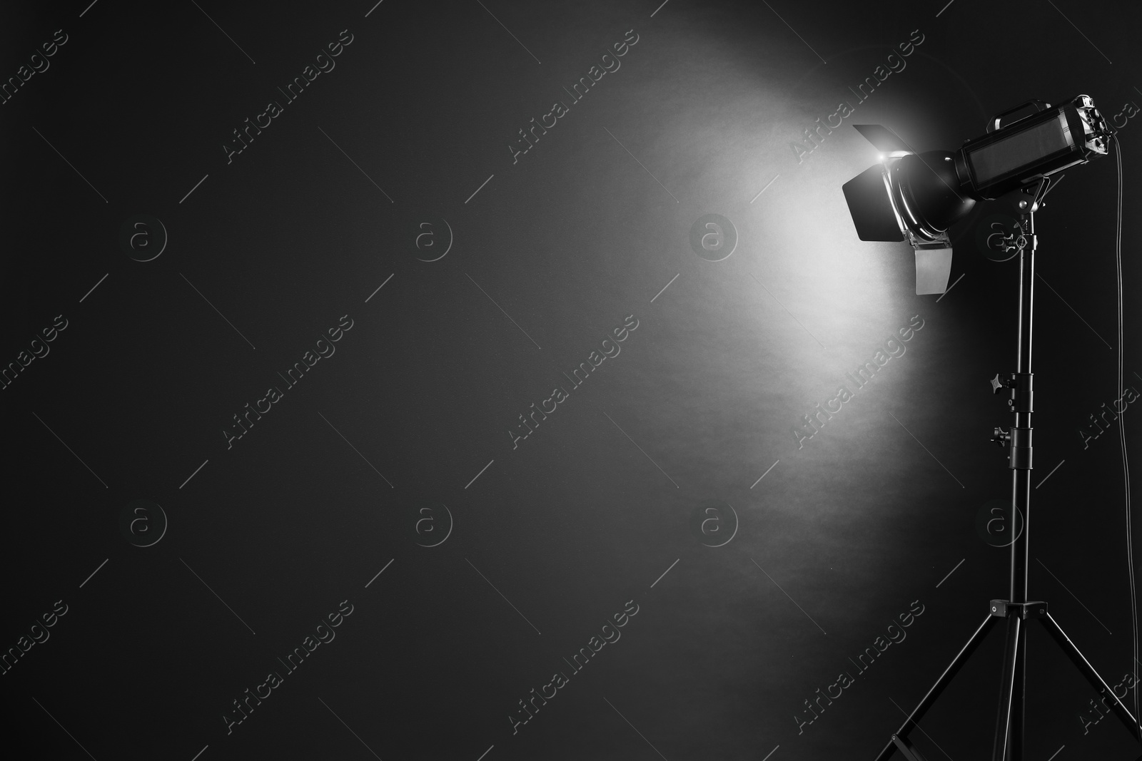 Photo of Dark photo background and professional lighting equipment in studio. Space for text