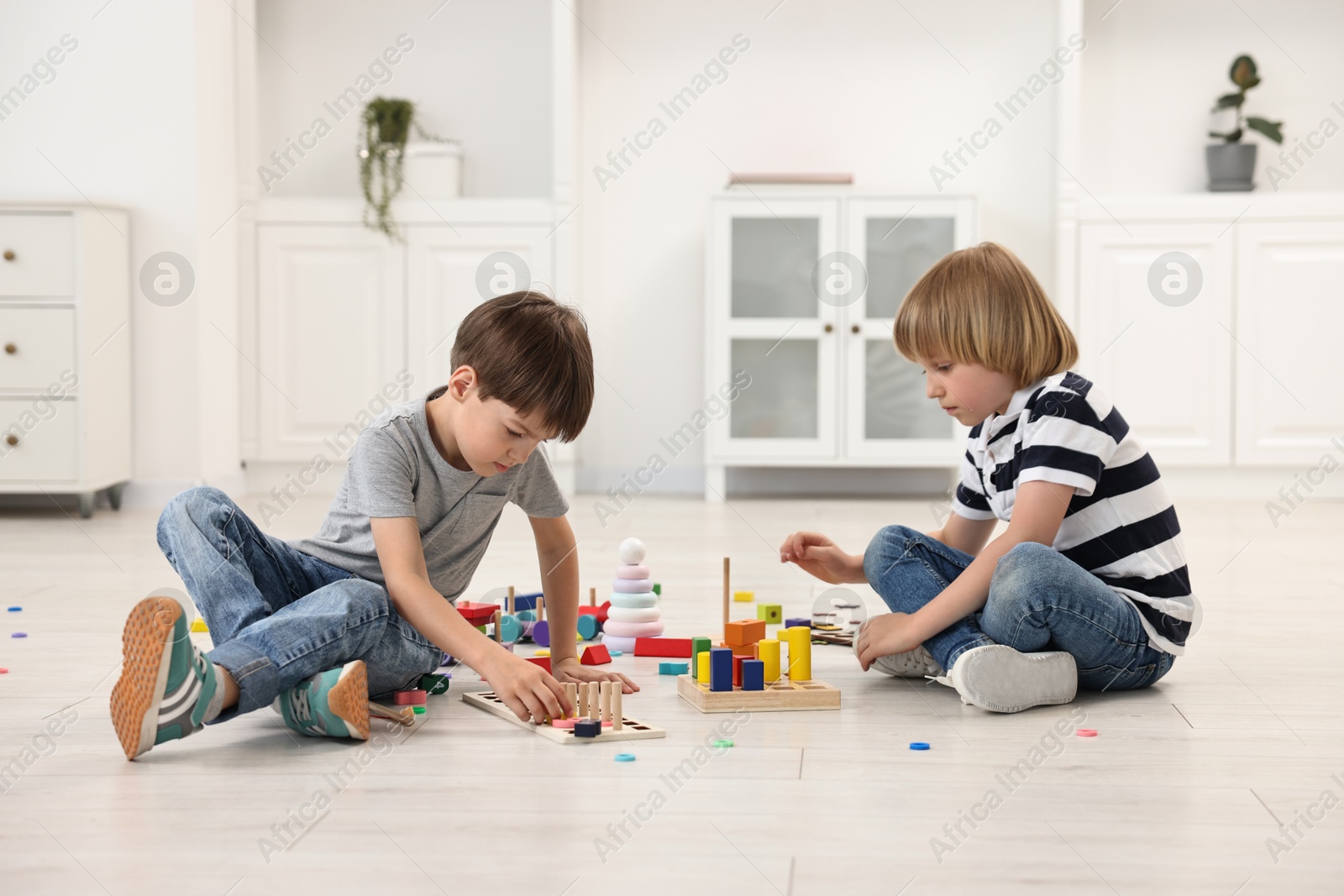 Photo of Cute little children playing together on floor indoors