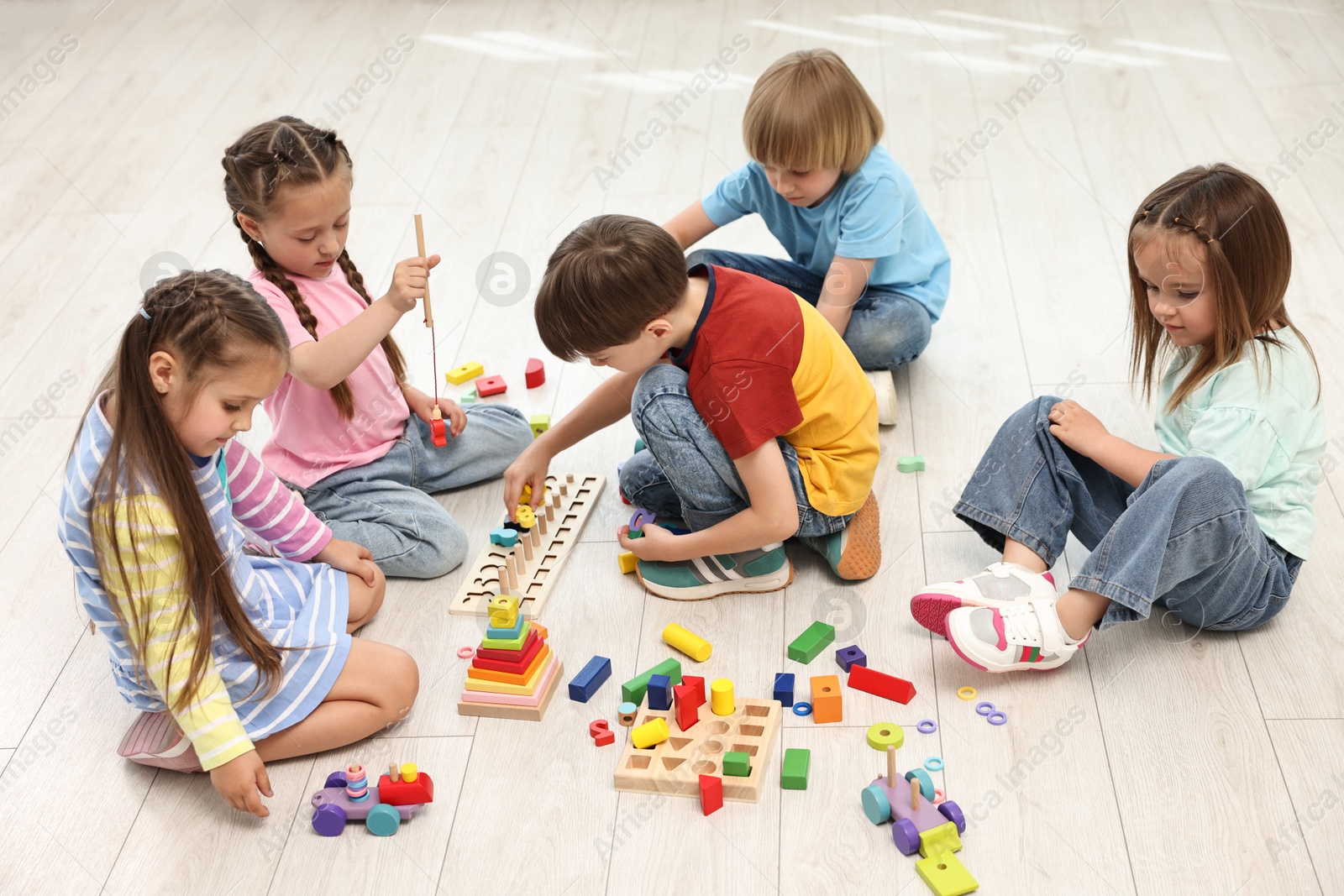 Photo of Group of children playing together on floor indoors