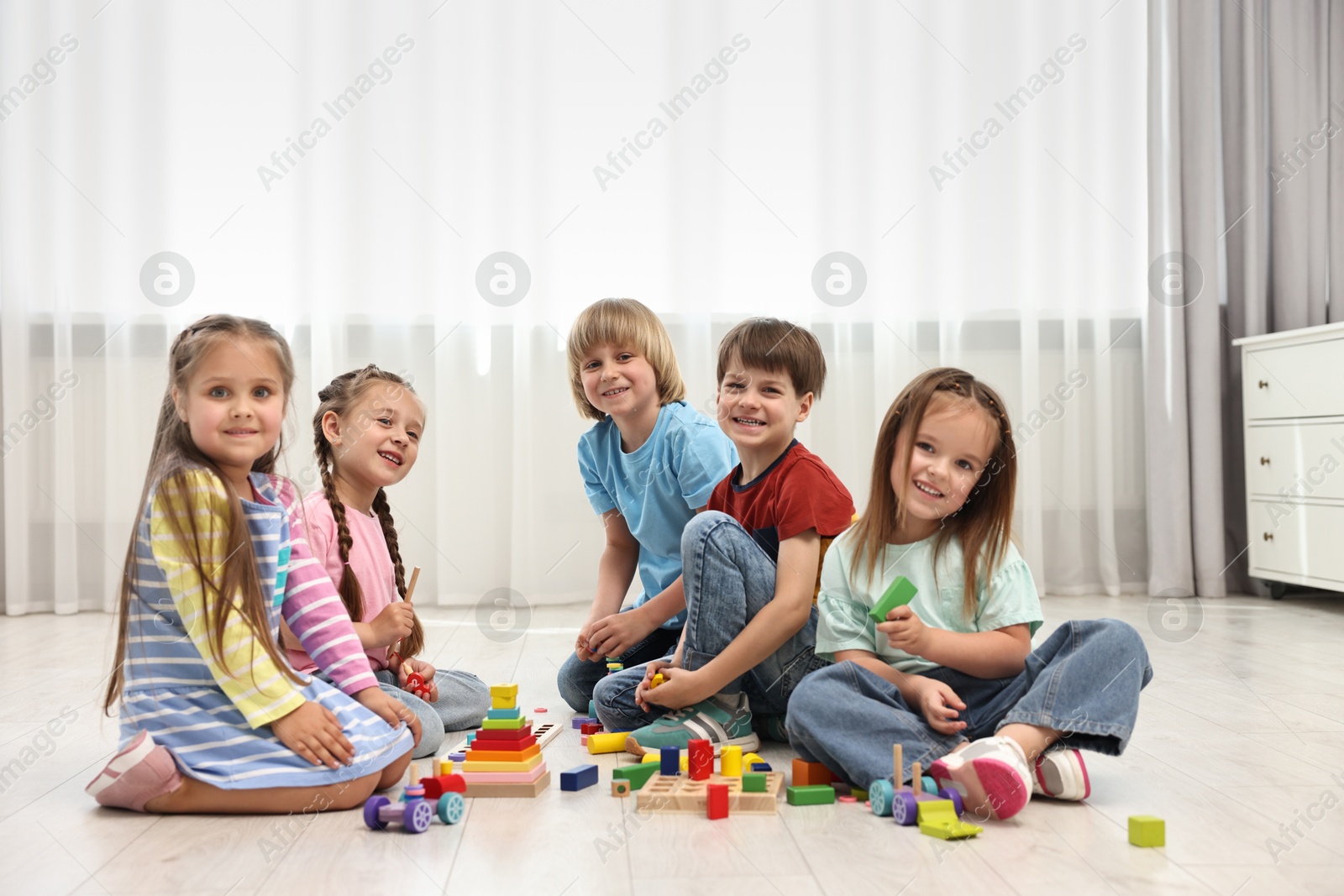 Photo of Group of children playing together on floor indoors