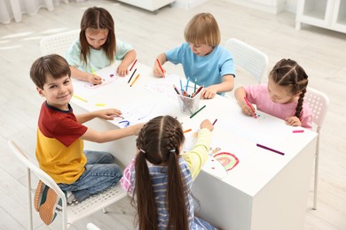 Group of children drawing at table indoors