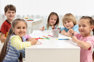 Group of children drawing at table indoors