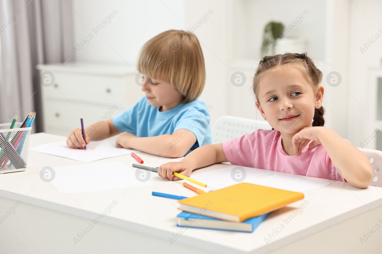 Photo of Cute little children drawing at table indoors