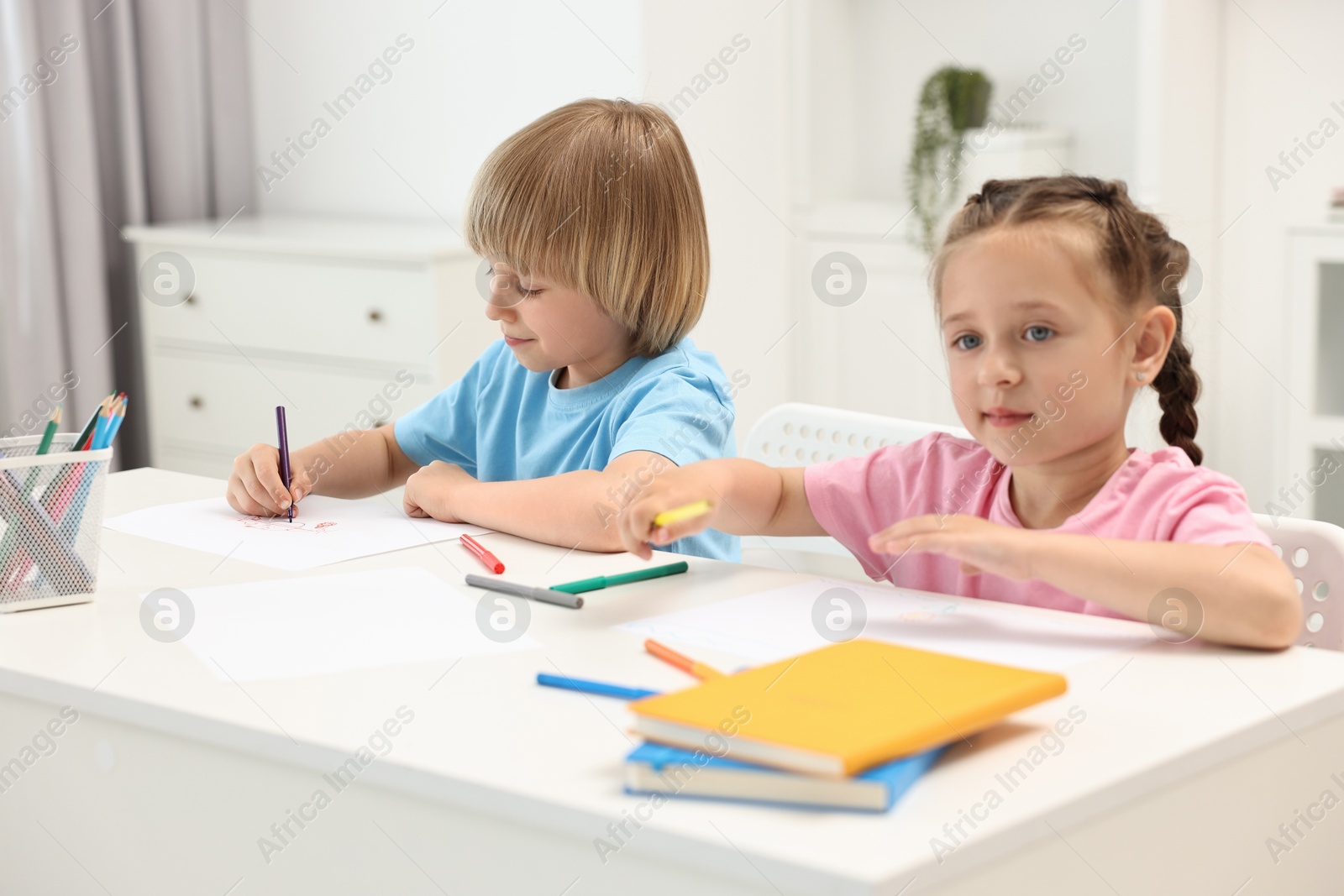 Photo of Cute little children drawing at table indoors