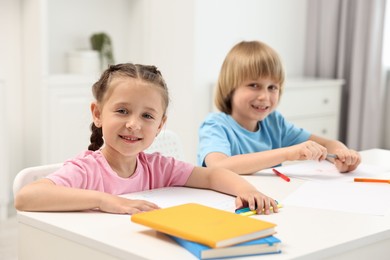 Cute little children drawing at table indoors