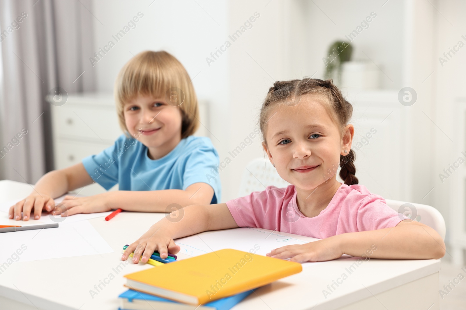 Photo of Cute little children drawing at table indoors