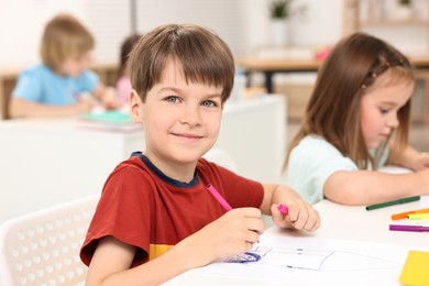 Cute little children drawing at table indoors