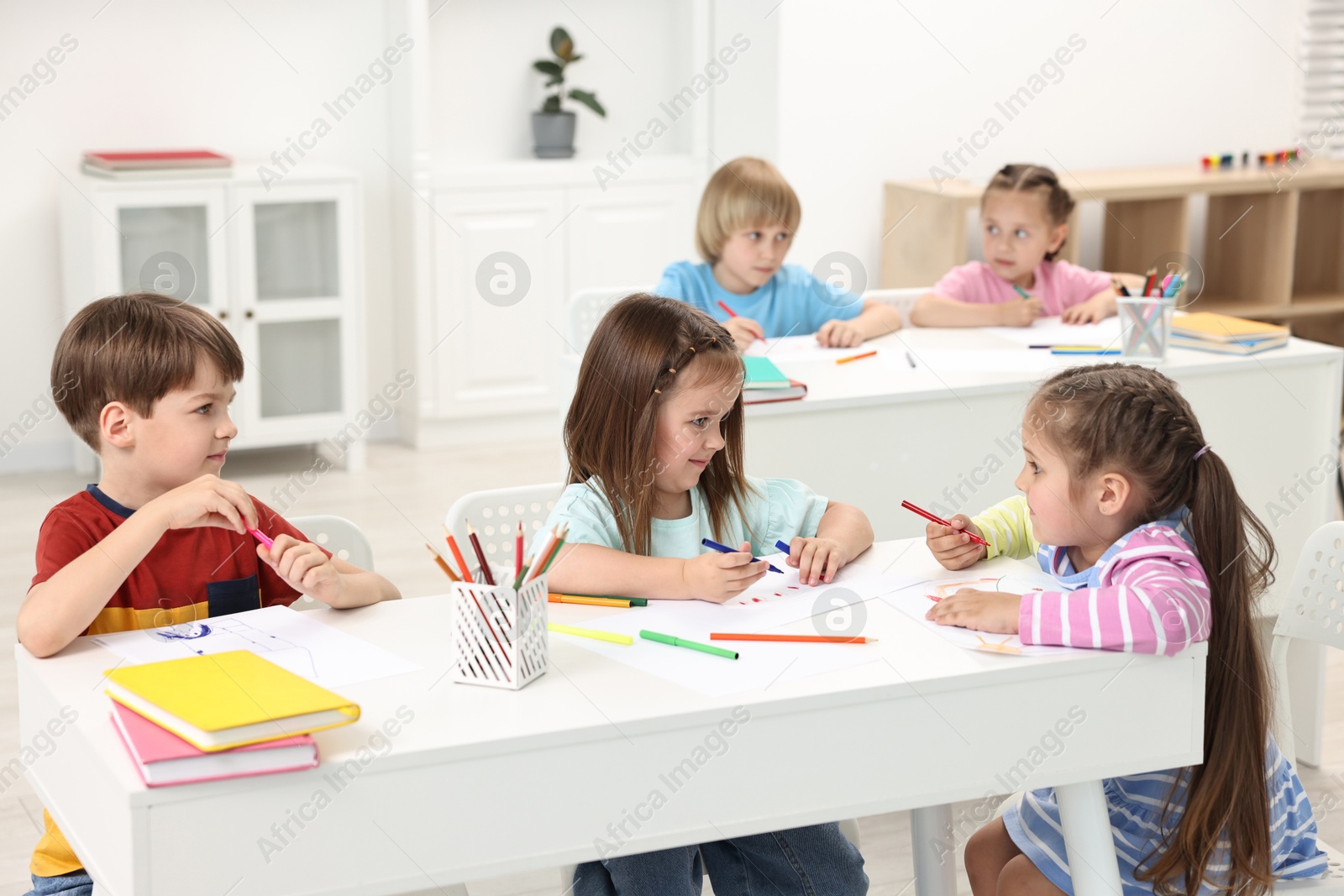 Photo of Group of children drawing at table indoors