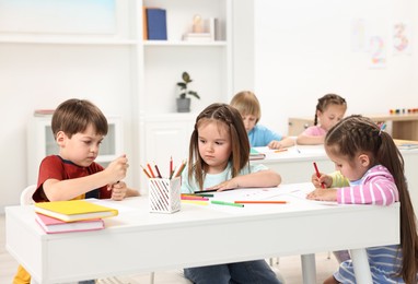 Photo of Group of children drawing at table indoors