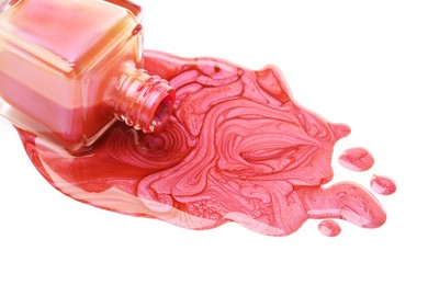 Overturned bottle of bright nail polish on white background, closeup