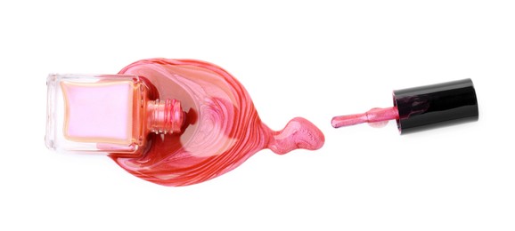 Overturned bottle of bright nail polish and brush isolated on white, top view