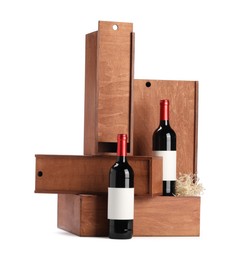 Photo of Wooden gift boxes with wine bottles isolated on white