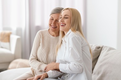 Family portrait of young woman and her mother at home