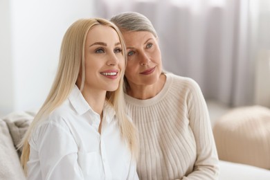 Family portrait of young woman and her mother at home