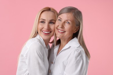 Photo of Family portrait of young woman and her mother on pink background