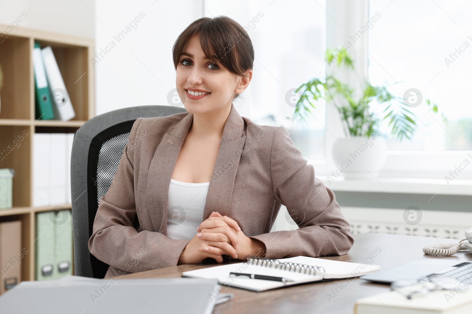 Photo of Portrait of smiling secretary at table in office